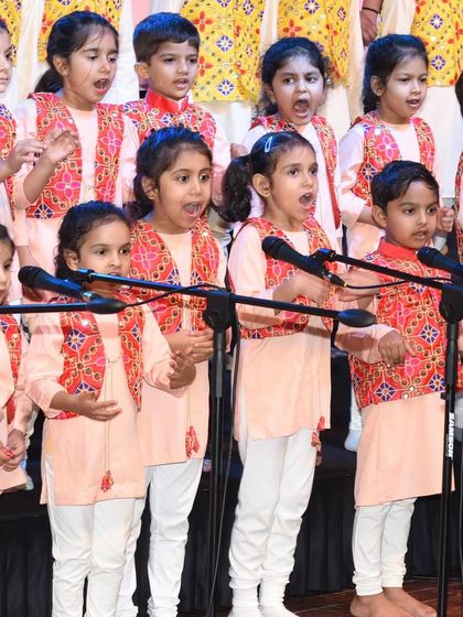 A close-up of our little singers during a stage performance. Their expressions show the concentration and joy they find in singing together as a choir.
