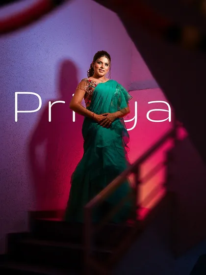 This shot uses creative lighting and perspective to frame the bride on a staircase. The purple and pink lights create a stylish, almost futuristic mood, turning a simple location into a dynamic backdrop for a modern bridal portrait.