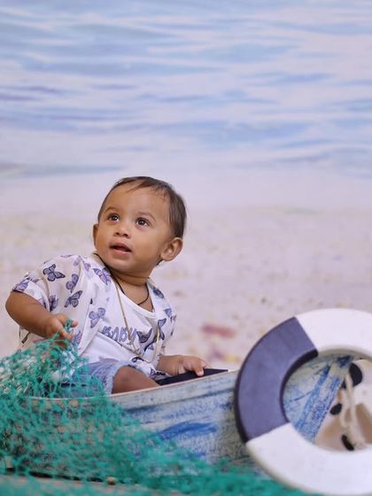 Explore our full nautical and beach-themed collection. These images showcase the variety of poses and angles possible with our boat prop, sand-colored flooring, and ocean backdrop.