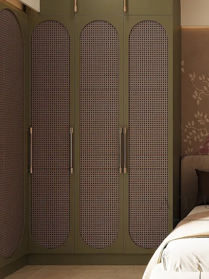 These olive green wardrobes feature unique arched doors with cane webbing, adding a touch of bohemian elegance to the bedroom.