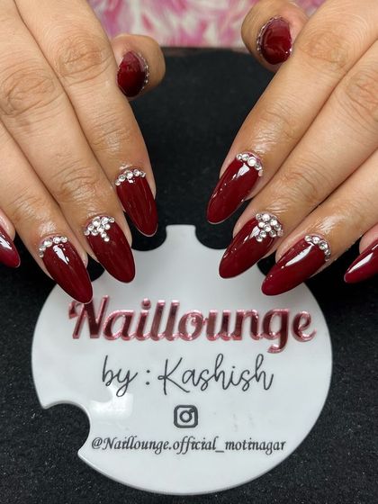 A glamorous deep red set on almond-shaped nails, with beautiful rhinestone clusters at the cuticle for a touch of sparkle.
