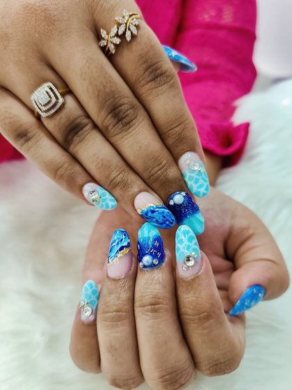 Another look at the dreamy beach shell nails, highlighting the beautiful blue tones and sparkling crystal and pearl accents.