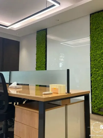 We integrate biophilic design elements like these preserved moss wall panels to improve air quality and reduce stress. This adds a touch of nature to the office, creating a healthier and more calming workspace for the team.