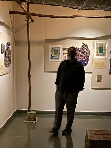 A visitor contemplates the works on display within the loom-like structure.