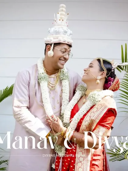 A sweet and happy portrait of the Bengali couple after their wedding ceremony, framed by lush green plants.