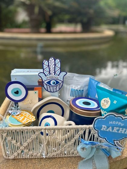 Another look at the evil-eye themed Rakhi hamper. This one is in a macrame basket and is filled with blue and white goodies.
