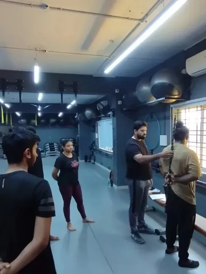 Our trainer provides one-on-one correction during a practical session. This personalized guidance on posture and movement is crucial for learning how to train clients safely.
