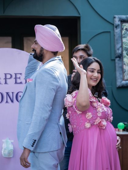 A candid moment of fun and games at the baby shower. This shot captures the couple's playful side and the joyful, relaxed atmosphere of the event.