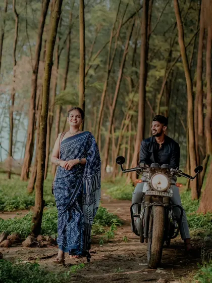 A stylish pre-wedding shot in a forest setting, featuring the couple with a motorcycle for a cool, rustic vibe. We love incorporating props that tell your story.