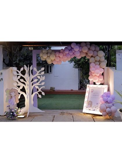 A grand entrance arch for a fairy party, featuring a pastel balloon garland and a stylized white tree prop, creating a magical entryway for guests.