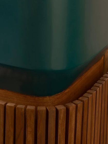This detail from the Sanctum site office highlights the precise meeting of materials. The deep green of the planter box contrasts beautifully with the fluted texture and warm tones of the teak wood, showcasing our commitment to refined craftsmanship.