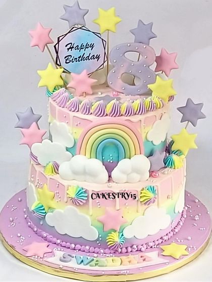 A joyful two-tier rainbow theme cake for an 8th birthday. The pastel-colored cake is decorated with fondant clouds, stars, and rainbow swirls for a cheerful celebration.