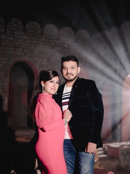 A formal portrait of a couple at night, with dramatic backlighting creating a spotlight effect. This showcases a more glamorous style of night photography.