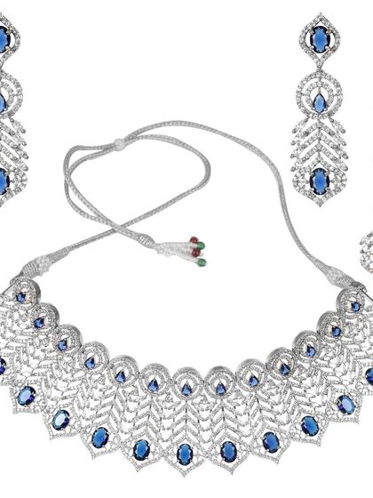 This American Diamond choker set with blue stones has a delicate, leaf-like pattern. It comes with matching earrings and a maang tikka for a complete, sparkling look.