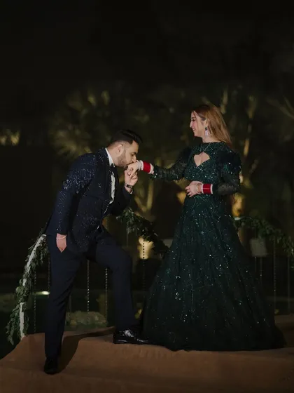 A chivalrous moment captured during the reception. The groom gently kisses the bride's hand, a classic romantic gesture that we love to capture against the backdrop of their evening celebration.