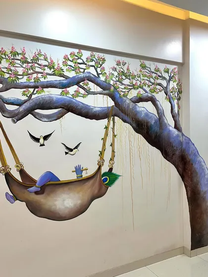 The finished mural, complete with pink blossoms, birds, and Krishna's signature peacock feather.