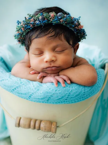 This is the heart of my newborn photography. A peacefully sleeping baby, posed safely and comfortably in a classic bucket prop, crowned with a delicate floral headband. These are the serene, timeless portraits I cherish creating.