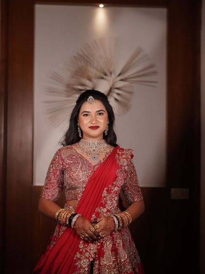 My beautiful bride, looking absolutely regal in her red reception lehenga. The makeup is glamorous and sophisticated.
