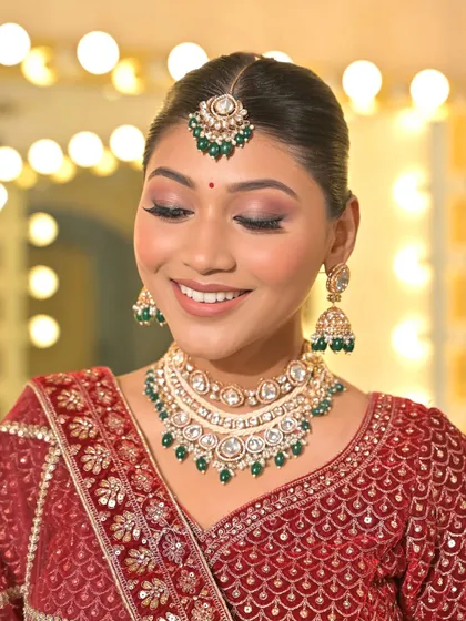 A closer look at the details that matter. This beautiful Kundan and green bead jewellery set includes a necklace, matching jhumka earrings, and a maang tikka, offering a touch of colour to complement your outfit.