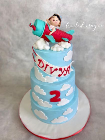 Up, up and away! This three-tiered aeroplane cake was for little Divya's second birthday. The highlight is the custom figurine of the birthday girl piloting her own plane through fluffy fondant clouds.