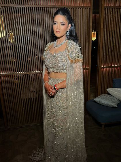 A full-length view of this sultry cocktail look. The high ponytail and glowing makeup create a chic, modern silhouette that is perfect for a glamorous evening event.