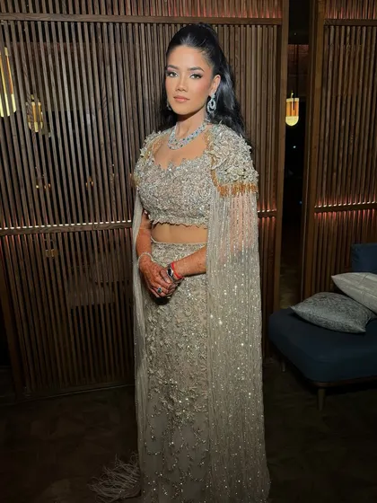 A full-length view of this sultry cocktail look. The high ponytail and glowing makeup create a chic, modern silhouette that is perfect for a glamorous evening event.
