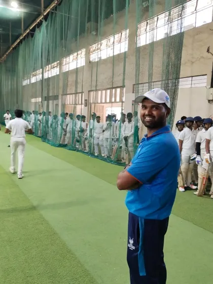 A coach smiling, encouraged by the display of talent and passion from the next generation of cricketers.