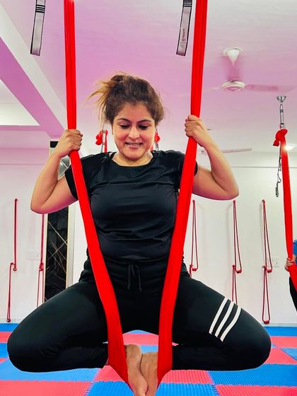 Getting into the hammock is the first step to a new adventure. This student smiles as she settles into the fabric, ready to explore the playful side of yoga.