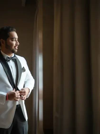 A classic groom portrait by the window. The soft, natural light creates a timeless and sophisticated look.