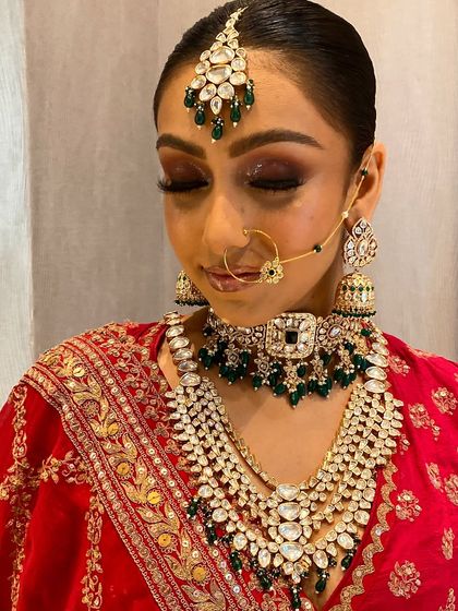 A close-up of a bride wearing our layered Kundan set. Notice the detail in the maang tikka and the way the choker and long necklace complement each other.