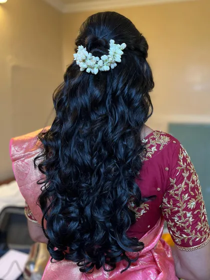Hema's reception hairstyle. A classic half-up, half-down look with beautiful curls and a simple malli poo arrangement.