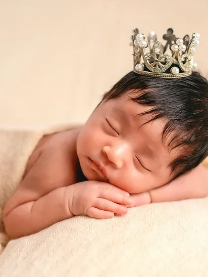 This is my classic posed newborn portrait style. I focus on the peaceful, sleepy expressions and tiny details of your baby, using soft textures and simple props like this delicate crown to create timeless, frame-worthy art.