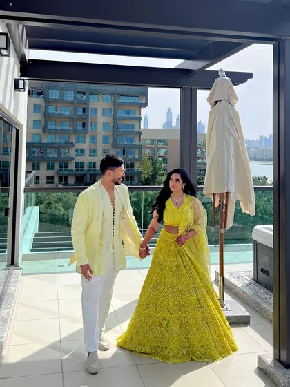 The couple posing on a balcony, the bride's long waves looking stunning against the city backdrop.