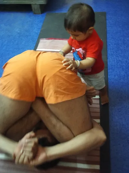 This is an old photo from 2017 with my little nephew, Moksh, who was one of my first "teachers." Children are naturally flexible and present, and he would often come to "adjust" me in poses like this Pindasana. It is a joyful memory of how practice is intertwined with family.