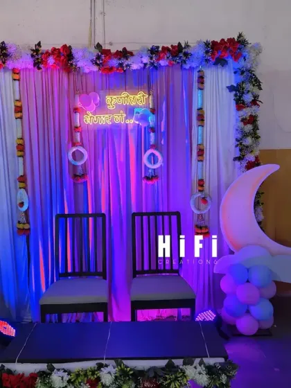 A traditional Dohale Jevan setup with two chairs for the parents-to-be, set against a backdrop of drapes and flowers.