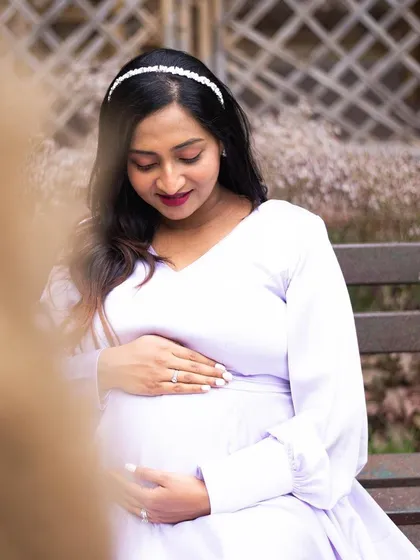 A serene solo portrait of an expecting mother gently holding her baby bump. The soft, natural lighting and her peaceful expression perfectly capture the quiet anticipation of motherhood.