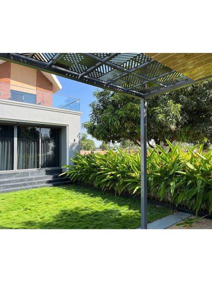 Looking back towards the villa from the pergola. The design ensures that the house and garden are always in dialogue, with lush greenery framing the view of the modern architecture.