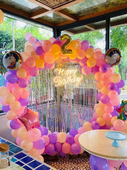 A full view of the unicorn-themed circular balloon arch for a second birthday.