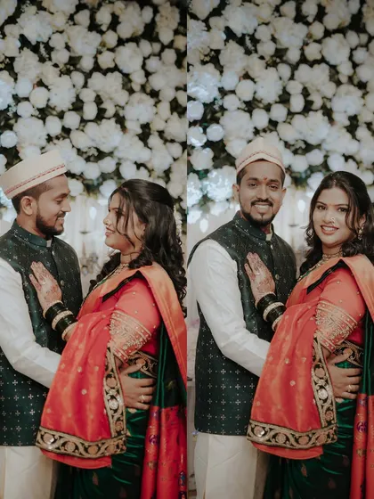 Posing against a wall of white flowers, the newly engaged couple looks radiant. These portraits capture both a loving glance and a happy smile for the camera.