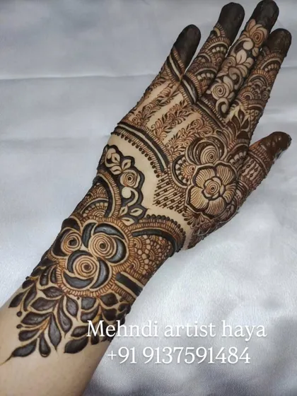 This design features bold, shaded roses on the forearm that transition into more intricate patterns on the hand, creating a balanced and elegant look.