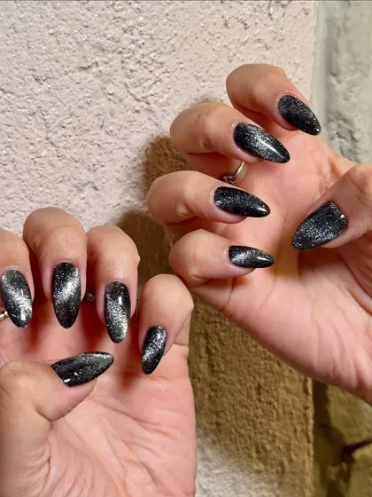 The silver magnetic streak in this black cat-eye polish gives the nails incredible dimension and a touch of mystery.