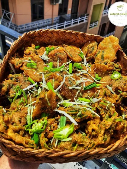 A basket full of freshly fried Bora. These savory fritters are crispy on the outside and soft on the inside.
