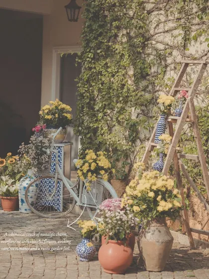 A whimsical photo corner with a rustic garden feel. We styled this nook with a vintage bicycle, a wooden ladder, and an abundance of flowers in terracotta pots and patterned vases.