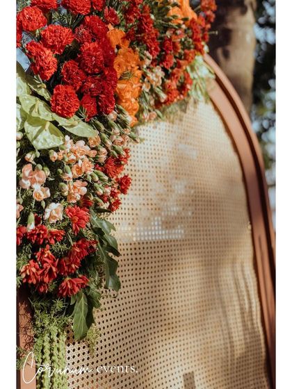 A close-up of the rattan backdrop, adorned with a lush arrangement of red and orange flowers.