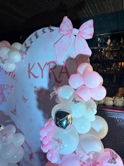 A close-up of our 'bow-tiful' half-birthday theme, featuring a large pink bow prop and personalized name sign on a custom backdrop.