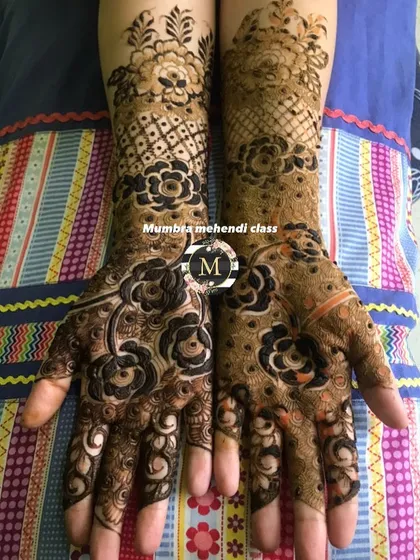 This design combines bold flowers with a delicate net pattern, a classic combination in Indian mehendi.