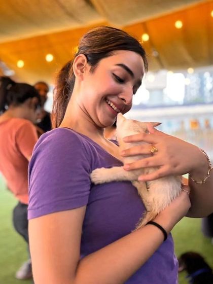 A participant shares a sweet, nuzzling moment with a white kitten, both looking happy and content.