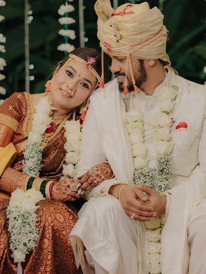 A quiet moment of togetherness on the wedding stage. The bride rests her head on the groom's shoulder, a simple gesture full of love and contentment.