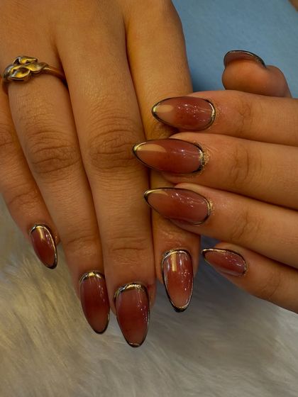 A full view of our elegant ombré nails with a gold chrome accent. This design is perfect for those who want a chic and polished look that is still unique and eye-catching.