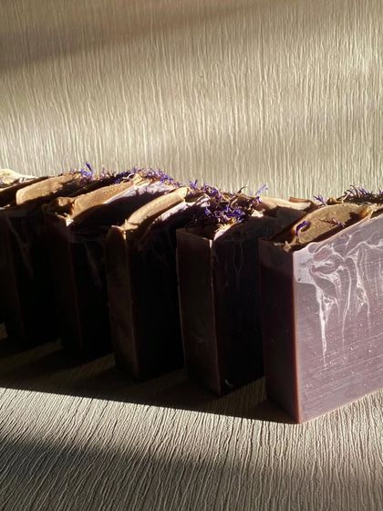 Our Purple Rain soap loaf, topped with dried botanicals before cutting. The calming aroma is a blend of Lavender, Geranium, and a touch of Vanilla and Lemon essential oils.